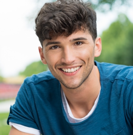 Teenage boy in blue tee shirt smiling after visiting dentist for teens in Hinsdale and Downers Grove