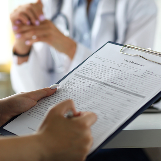 Person filling out paperwork on clipboard