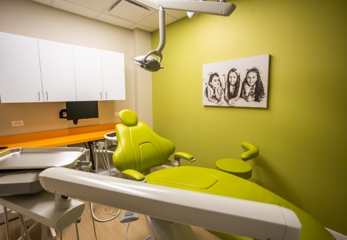 Dental team member smiling next to young boy in dental chair