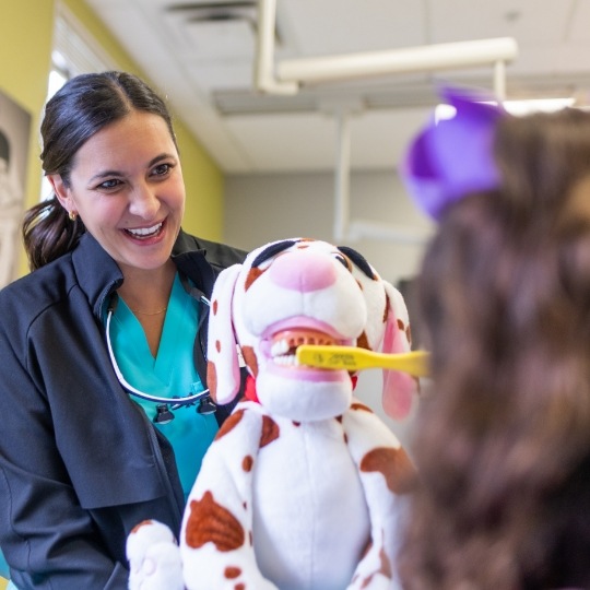 Young girl smiling in dental chair during pediatric preventive dentistry checkup