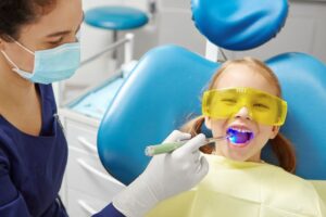 a child having a dental sealant cured by a pediatric dentist