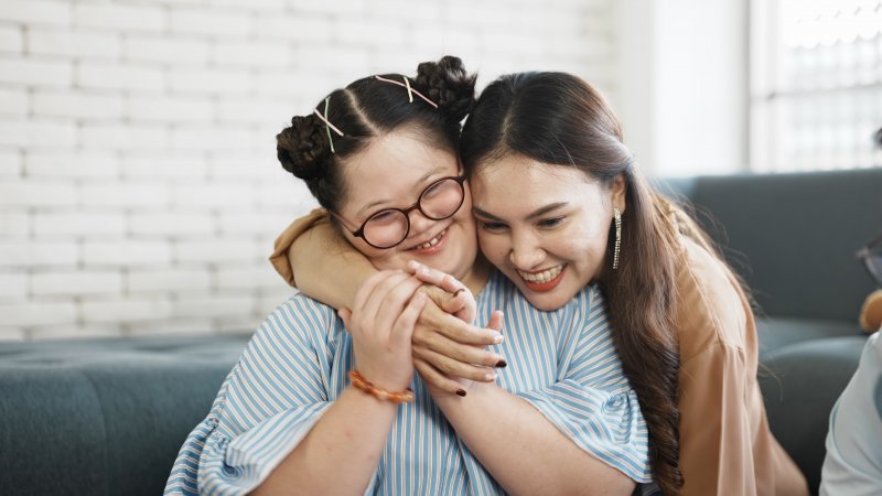 woman hugging young girl with Down syndrome