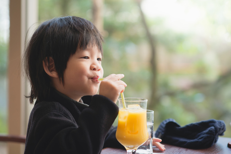 Young patient with good dental health drinking fruit juice