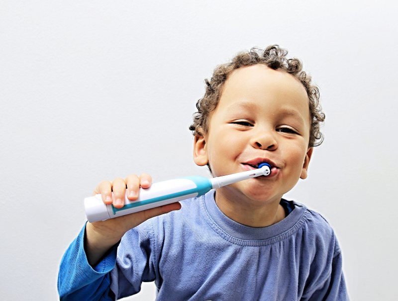 child using an electric toothbrush