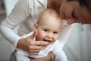 a parent massaging their teething baby's gums